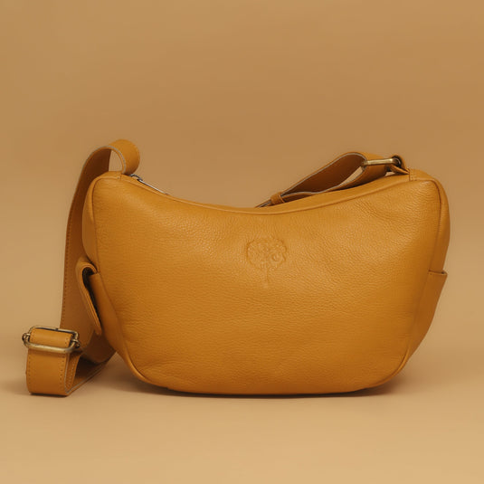 Eco-leather banana shoulder bag in mustard yellow with curved silhouette and adjustable strap