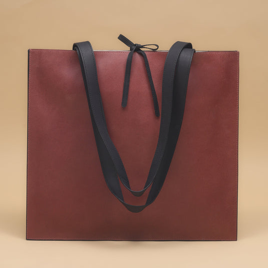 Eco-leather slim tote bag in brown with black straps, minimalist and lightweight design for everyday use