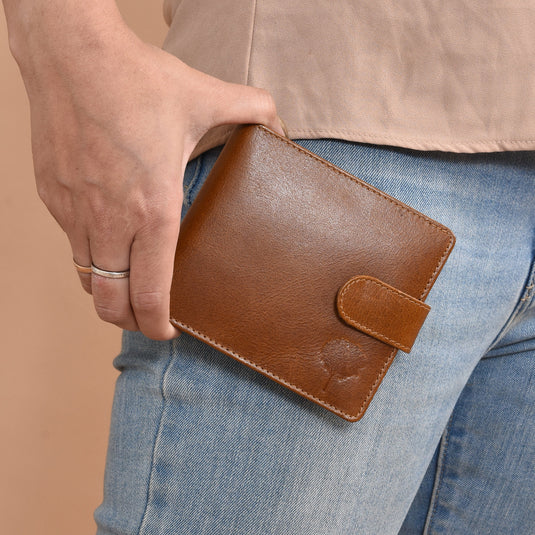 Eco-leather ginger wallet with embossed tree design held in hand against jeans background
